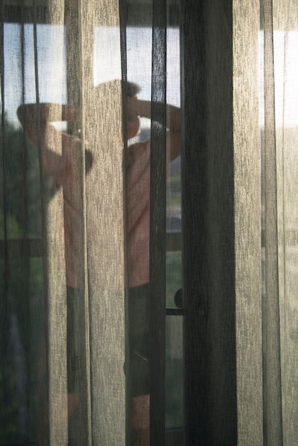 Foto grátis retrato de homem adulto com cortinas e sombra da janela