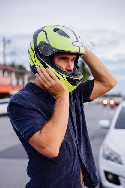 Foto grátis retrato de motociclista com capacete amarelo em uma estrada movimentada na tailândia, ao pôr do sol