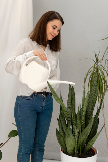 Foto grátis retrato de mulher regando planta