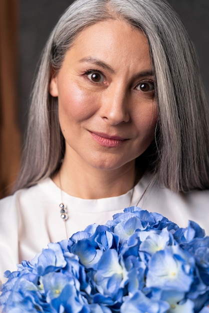 Foto grátis retrato de mulher sênior com buquê de flores