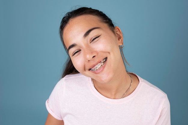 Foto grátis retrato de uma adolescente sorridente com aparelho