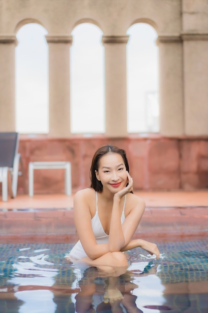 Foto grátis retrato de uma bela jovem asiática relaxando na piscina