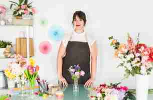 Foto grátis retrato de uma florista feminina com vasos de flores na mesa