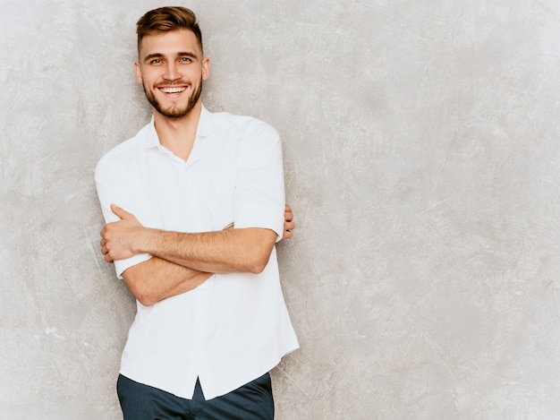 Foto grátis retrato do modelo de empresário de sorriso bonito hipster vestindo camisa casual de verão branco. .braços cruzados