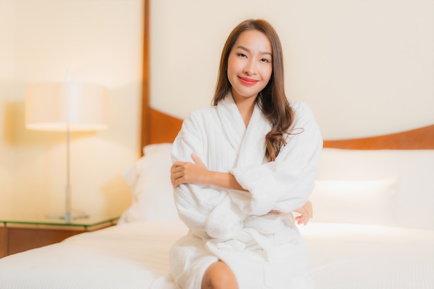 Foto grátis retrato linda jovem asiática sorrindo relaxando na cama no interior do quarto