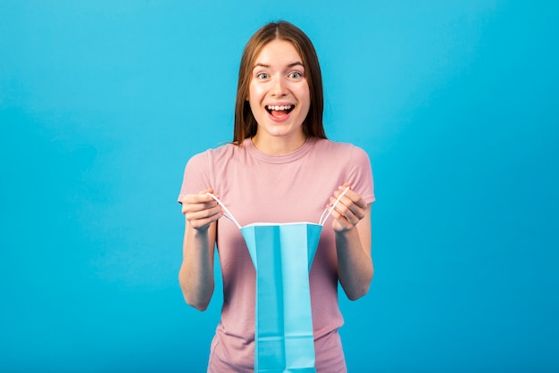 Foto grátis retrato médio-tiro de uma mulher feliz, segurando uma sacola de compras