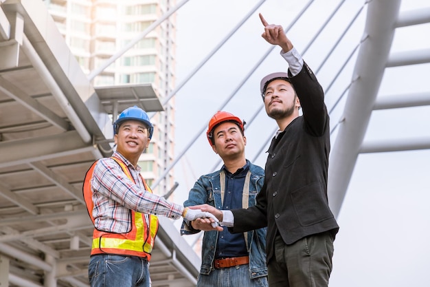 Foto grátis reunião de gerente com engenheiro na mão de pilha de site ao ar livre para trabalho em equipe