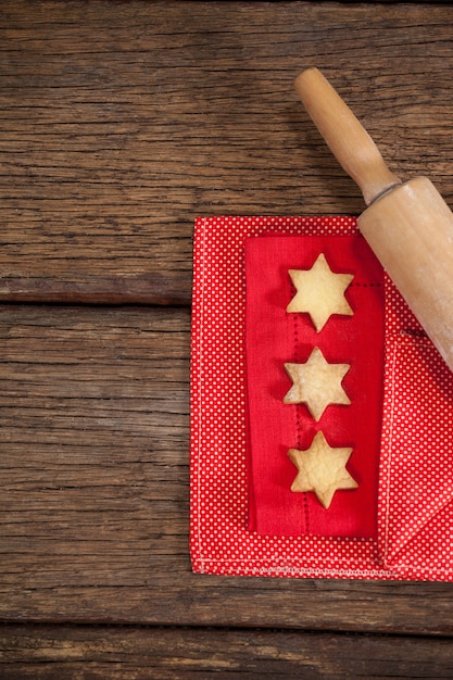 Foto grátis rolar com biscoitos em forma de estrela em uma mesa de madeira