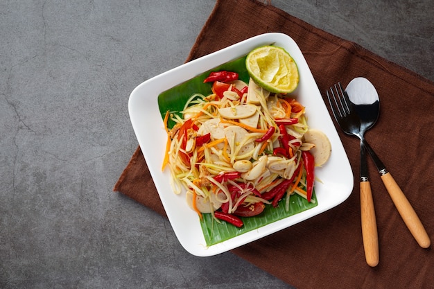 Foto grátis salada de papaia servida com macarrão de arroz e salada de vegetais decorada com ingredientes da comida tailandesa.