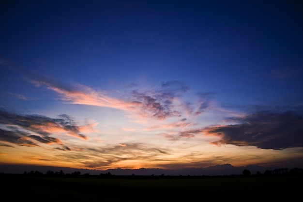 Foto grátis silhuetas de colinas sob um céu nublado durante um lindo pôr do sol