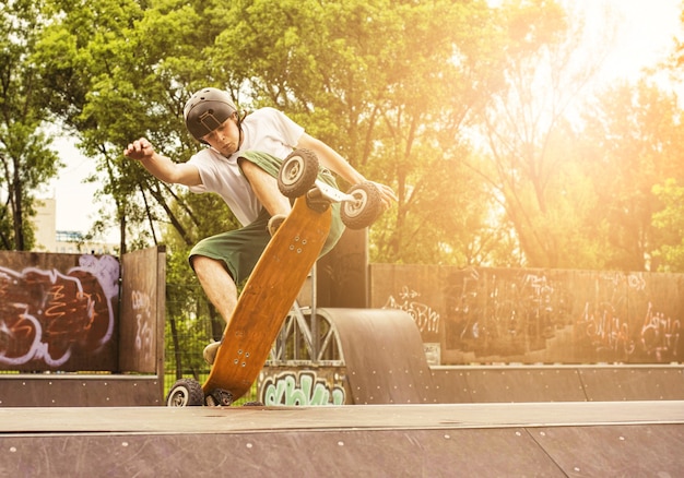 Foto grátis skatista fazendo uma manobra no skatepark sob os raios do sol