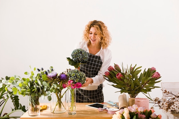 Foto grátis tiro médio mulher que trabalha em uma loja de flores