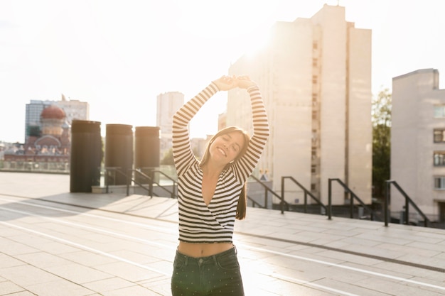 Foto grátis tiro médio mulher sorridente posando na luz solar