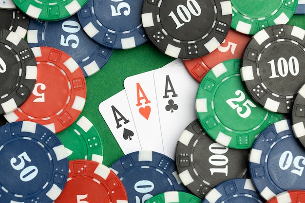 Foto grátis tokens de cassino em fundo verde com cartas ace