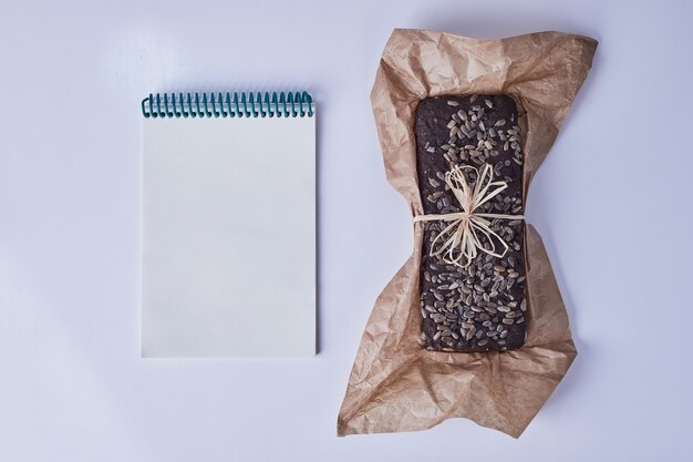 Torta de brownie em um pedaço de papel com um livro de receitas à parte.