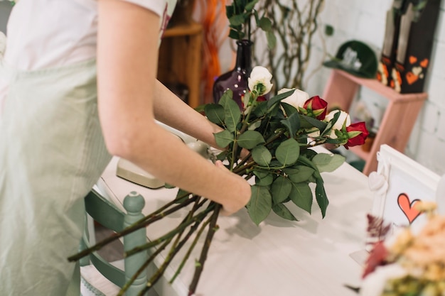 Foto grátis trabalhador de colheita que compõe rosas