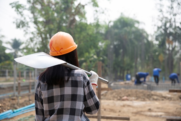 Foto grátis trabalhadores da construção civil carregando uma pá para o canteiro de obras