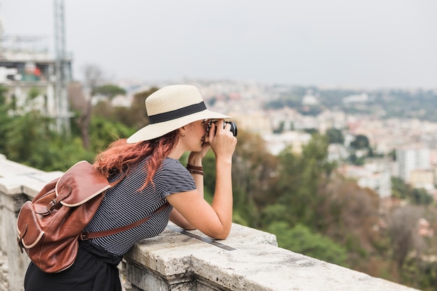 Foto grátis turismo feminino com câmera na varanda