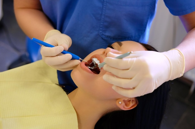 Foto grátis um dentista mãos trabalhando em paciente jovem com instrumentos odontológicos.