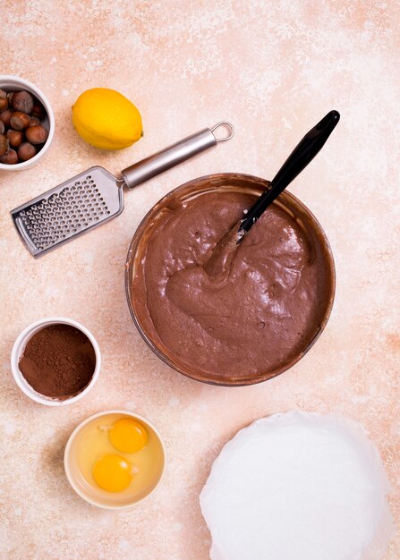 Uma visão aérea de massa de chocolate com ingredientes no balcão da cozinha