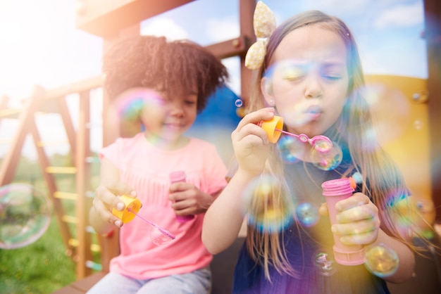 Veja crianças felizes brincando com bolhas de sabão