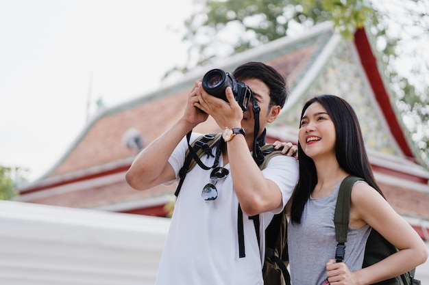 Foto grátis viajante casal asiático usando a câmera para tirar uma foto ao passar a viagem de férias em bangkok, tailândia