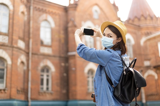 Foto grátis viajante elegante com chapéu tirando fotos de férias