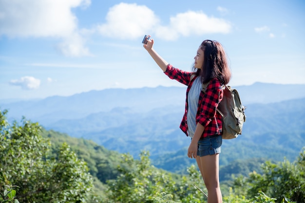 Foto grátis viajantes, mulheres jovens, olhem para as incríveis montanhas e florestas, ideias de viagens por viagens,