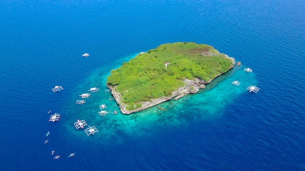 Foto grátis vista aérea da praia de areia com turistas que nadam na linda água do mar clara da ilha de sumilon, pousando na praia perto de oslob, cebu, filipinas. - impulse o processamento de cores.