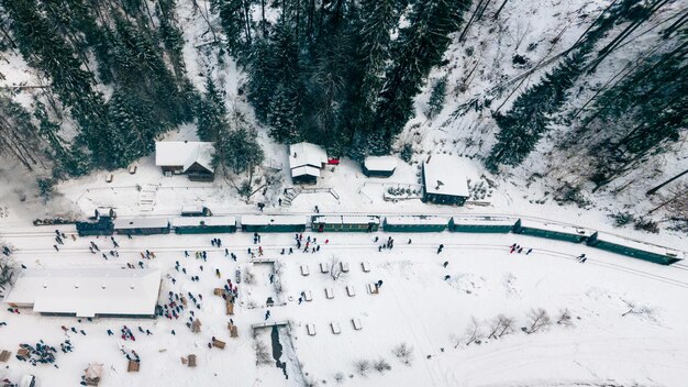 Vista aérea de drones do trem a vapor Mocanita em uma estação ferroviária na neve do inverno