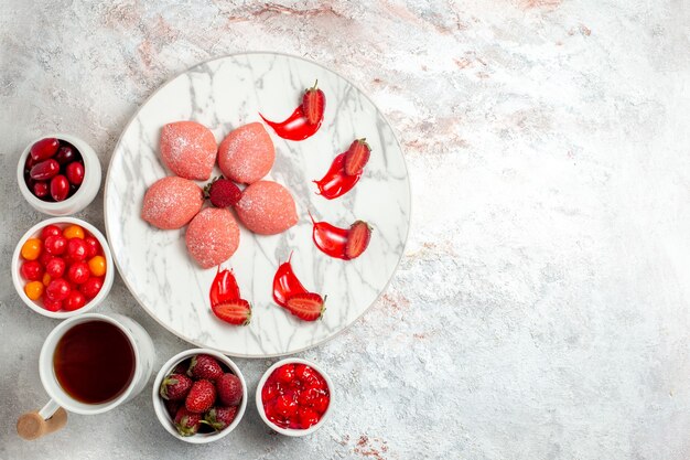 Vista de cima bolos de morango rosa com frutas no fundo branco