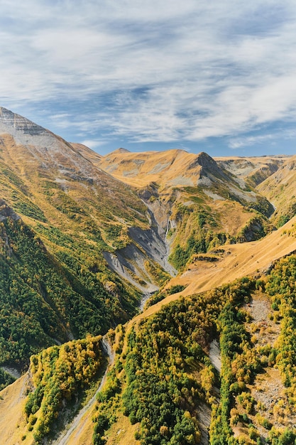 Foto grátis vista de quadro vertical do desfiladeiro com uma cachoeira do planalto da montanha outono nas montanhas ideia para um banner ou cartão postal com espaço para viagem de texto para a geórgia trekking nas montanhas