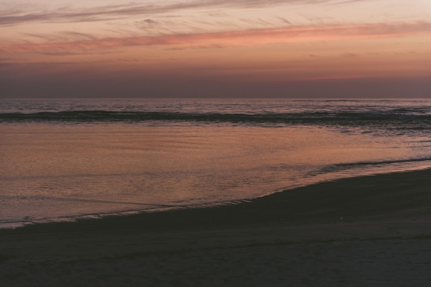 Foto grátis vista fascinante do oceano e da praia durante o pôr do sol