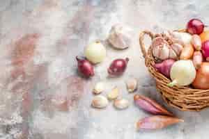 Foto grátis vista frontal de diferentes ingredientes, cebola e alho dentro da cesta