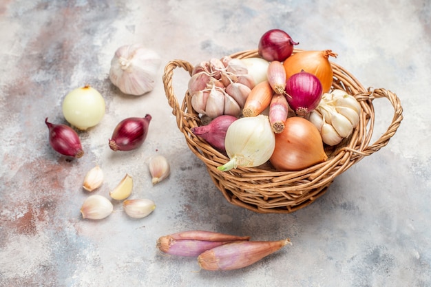 Foto grátis vista frontal de diferentes ingredientes, cebola e alho dentro da cesta