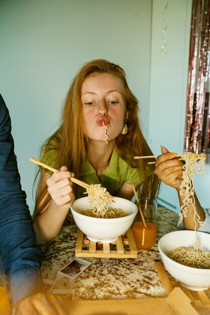 Vista frontal mulher comendo macarrão