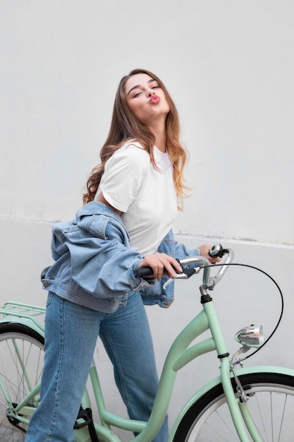 Foto grátis vista lateral de uma mulher fazendo beicinho enquanto está sentada em sua bicicleta