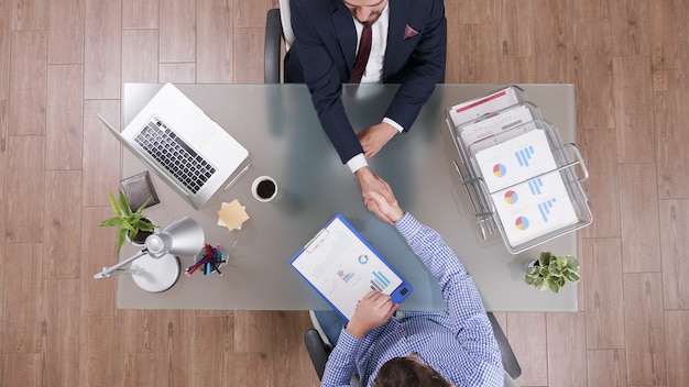 Foto grátis vista superior de empresários apertando as mãos durante a negociação comercial no escritório de inicialização