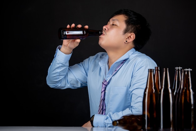 Kostenlose Foto alkoholischer asiatischer mann mit vielen bierflaschen