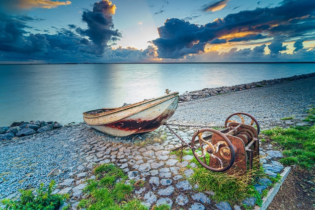 Kostenlose Foto altes rostiges fischerboot am hang am ufer des sees