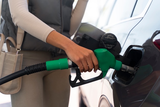 Kostenloses Foto ansicht einer frau mit auto an der tankstelle