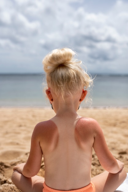 Kostenloses Foto ansicht eines jungen mädchens mit sonnenbrandhaut am strand