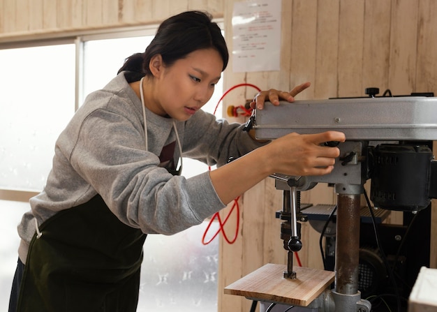 Kostenloses Foto asiatische frau, die mit holz arbeitet