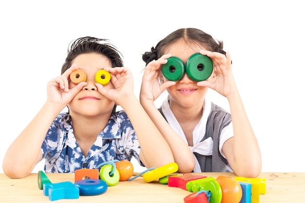 Kostenloses Foto asiatischer junge und mädchen spielen glücklich buntes hölzernes blockspielzeug