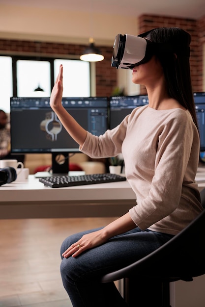 Kostenloses Foto asiatischer techniker mit vr-brille entwickelt produkt und hilft bei der produktion von industriemaschinen. cad-ingenieur, der zahnradmodelle mit virtual-reality-3d-headset und software herstellt.