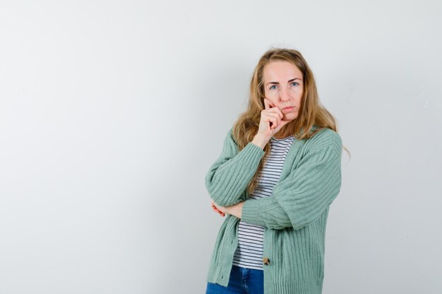 Ausdrucksstarke junge Frau, die im Studio aufwirft