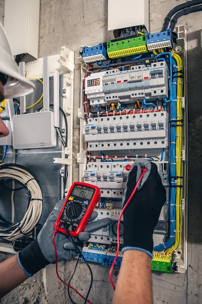 Kostenloses Foto bemannen sie einen elektrotechniker, der in einer schalttafel mit sicherungen arbeitet