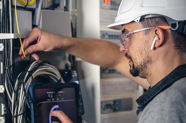 Kostenloses Foto bemannen sie einen elektrotechniker, der in einer schalttafel mit sicherungen arbeitet