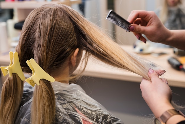 Kostenloses Foto blondes mädchen, das ihr haar erledigt erhält