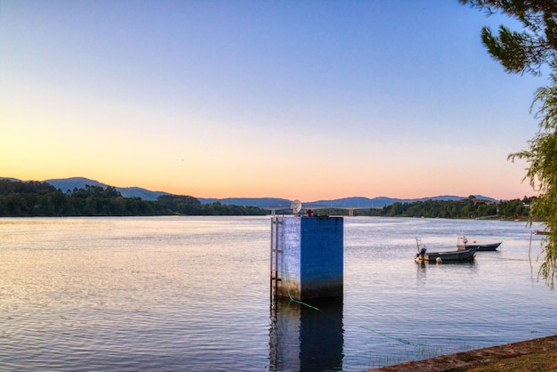 Kostenloses Foto boote auf der ruhigen see unter dem rosa und blauen himmel